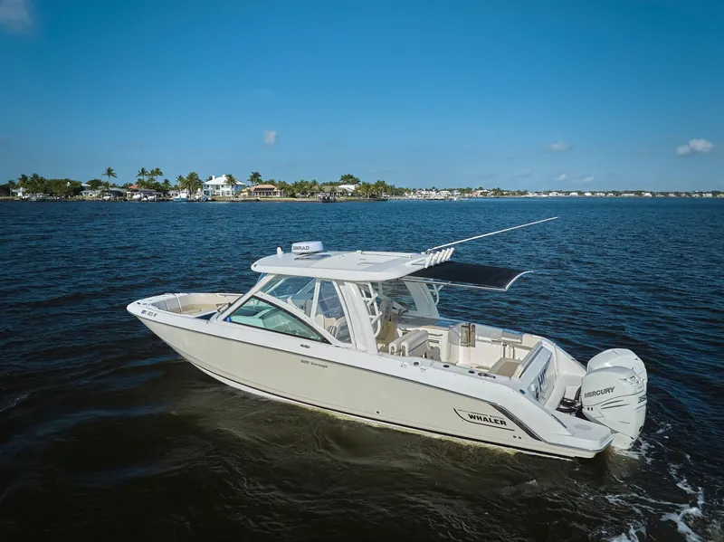 Slide: The Image of 2016 Boston Whaler 320 Vantage boat cruising on open water under clear blue skies. - 35