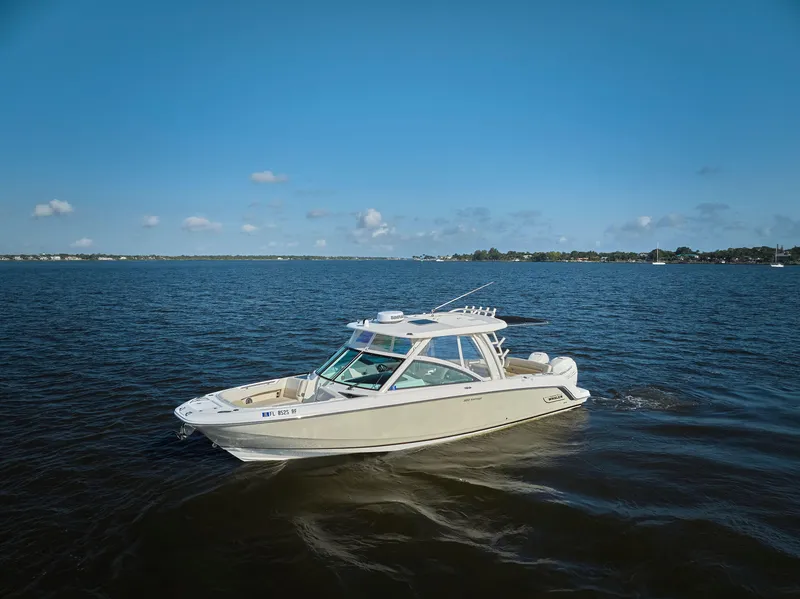 Slide: The Image of 2016 Boston Whaler 320 Vantage boat cruising on open water under clear blue sky. - 36