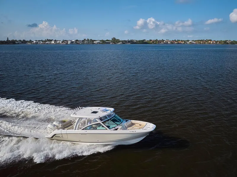 Slide: The Image of 2016 Boston Whaler 320 Vantage cruising on open water under a clear blue sky. - 42