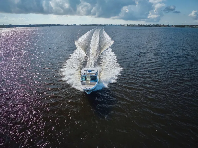 Slide: The Image of 2016 Boston Whaler 320 Vantage cruising on open water under a cloudy sky. - 44