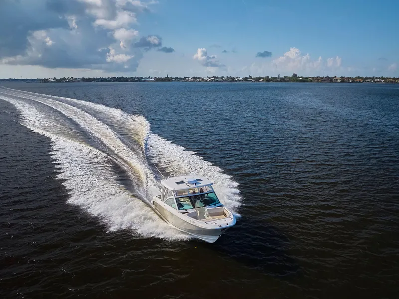 Slide: The Image of 2016 Boston Whaler 320 Vantage cruising on open water under a clear blue sky. - 45