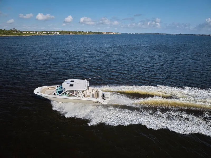 Slide: The Image of 2016 Boston Whaler 320 Vantage cruising on open water under clear skies. - 46