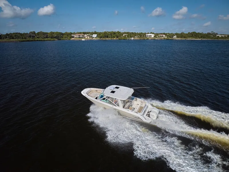 Slide: The Image of 2016 Boston Whaler 320 Vantage cruising on a sunny day, creating a wake in the water. - 47