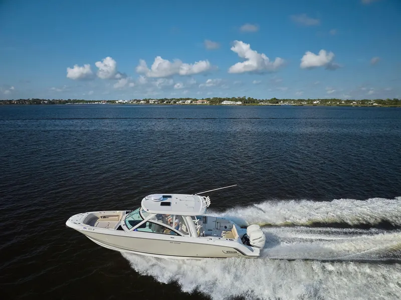 Slide: The Image of 2016 Boston Whaler 320 Vantage cruising on a sunny day, creating a wake in calm waters. - 50