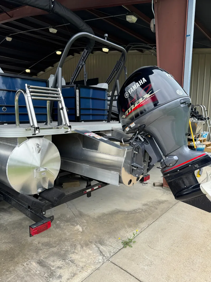 Slide: The Image of 2025 Veranda Vista View 20RC pontoon boat with Yamaha outboard motor in a storage facility. - 8