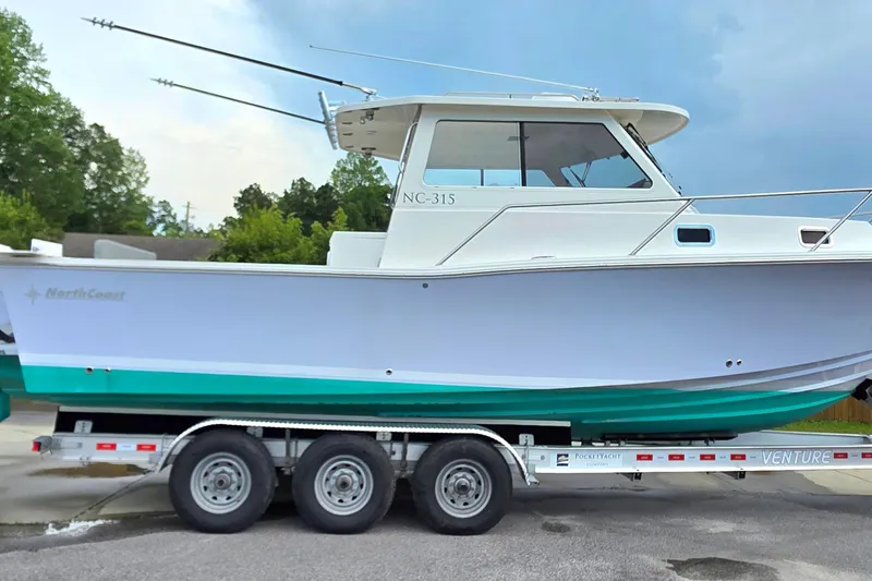 Slide: The Image of 2024 NorthCoast 315 HT boat on trailer, side view, outdoors. - 0