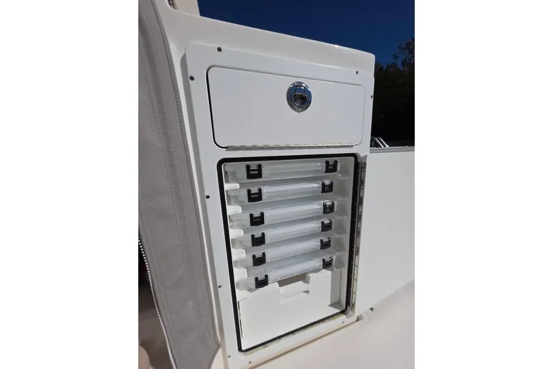Slide: The Image of 2024 NorthCoast 315 HT boat storage compartment with multiple drawers, open under clear blue sky. - 18