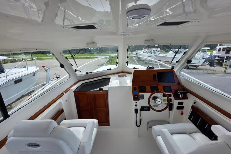 Slide: The Image of Interior of 2024 NorthCoast 315 HT boat, featuring modern helm and seating. - 2