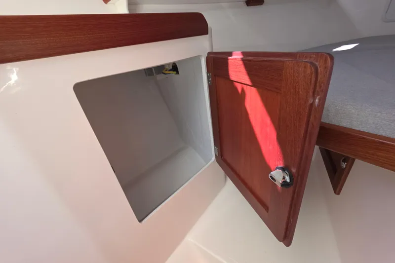 Slide: The Image of 2024 NorthCoast 315 HT cabin storage with open wooden door and interior view. - 24