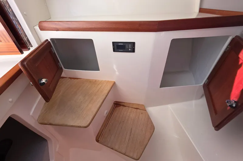 Slide: The Image of 2024 NorthCoast 315 HT interior storage compartments with wooden accents and control panel. - 25