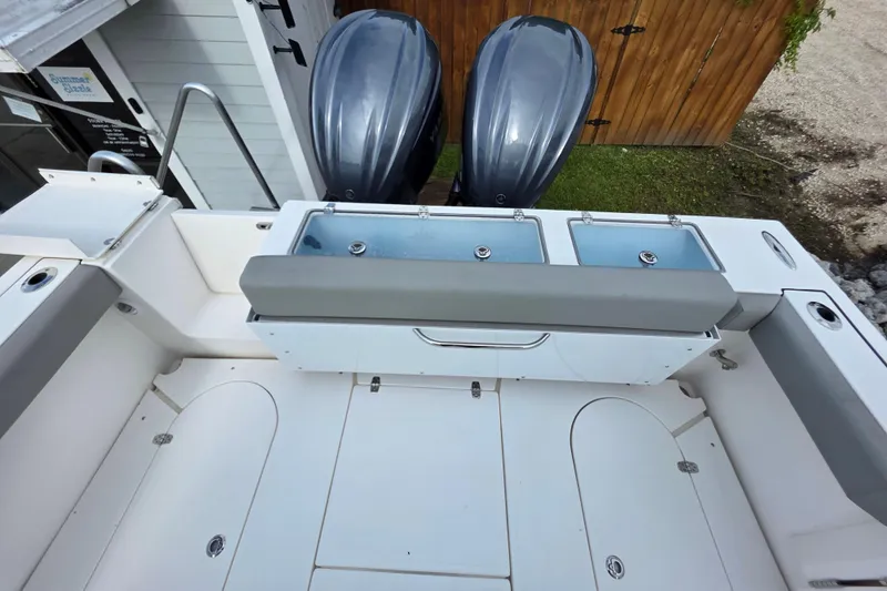 Slide: The Image of 2024 NorthCoast 315 HT boat deck with dual outboard motors and storage compartments. - 6