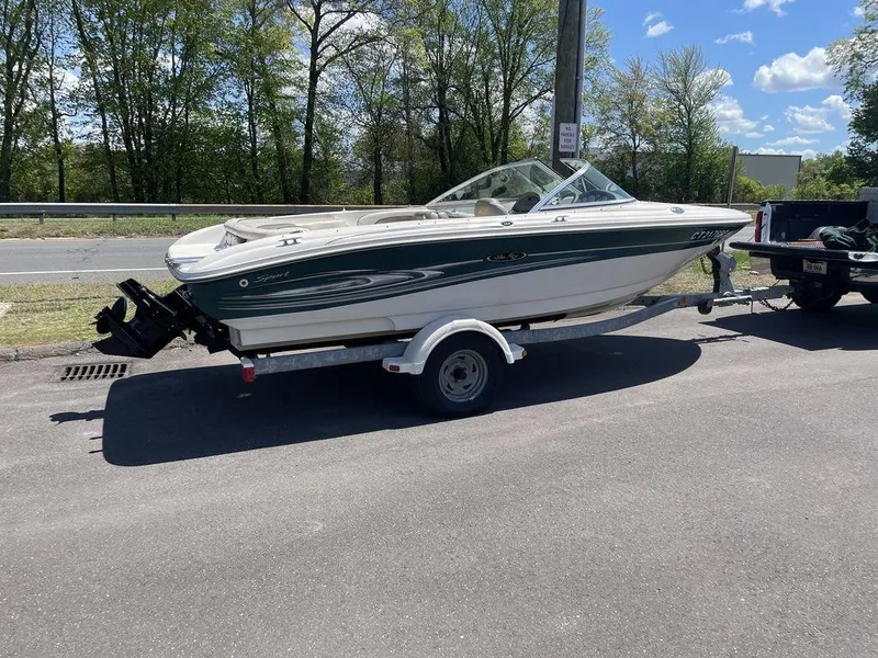 Slide: The Image of 2004 Sea Ray 185 Sport boat on trailer, parked outdoors on a sunny day. - 14