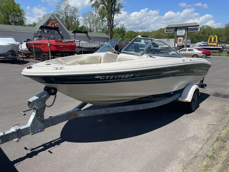 Slide: The Image of 2004 Sea Ray 185 Sport boat on trailer in parking lot, sunny day. - 17