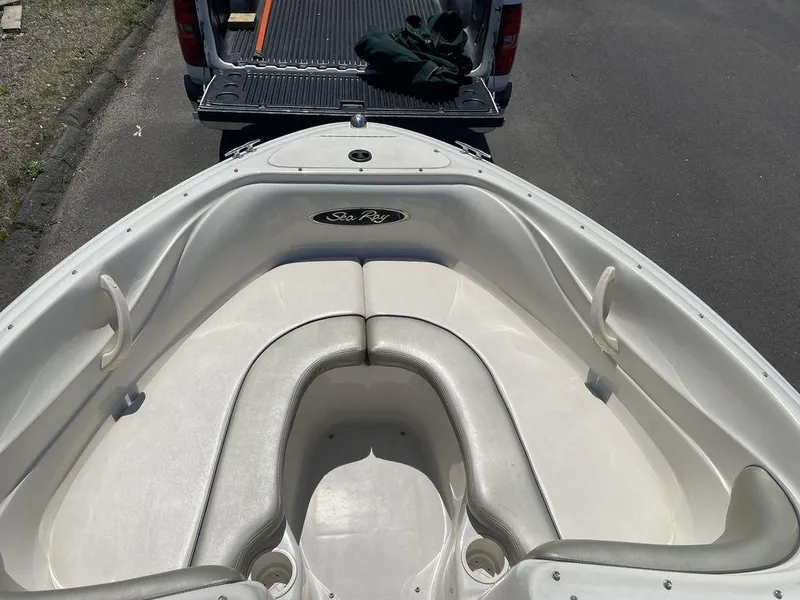 Slide: The Image of 2004 Sea Ray 185 Sport boat interior with white seating and logo. - 8