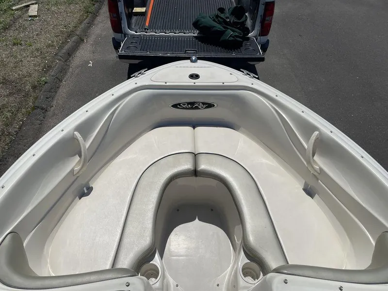 Slide: The Image of 2004 Sea Ray 185 Sport boat interior with seating, parked near a truck. - 9