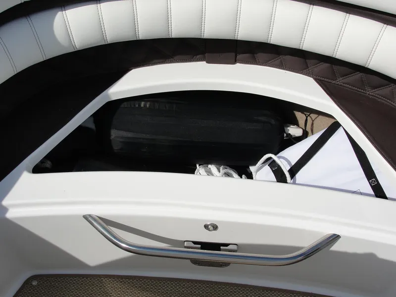 Slide: The Image of 2013 Cobalt A25 boat storage compartment with white and black interior. - 24
