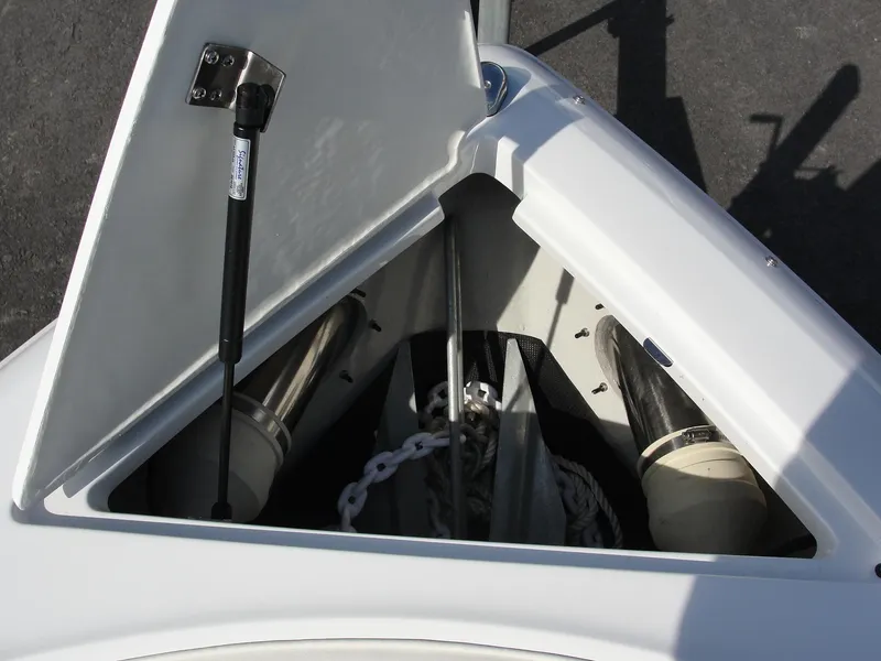 Slide: The Image of 2013 Cobalt A25 boat anchor compartment with open hatch and chain storage. - 25