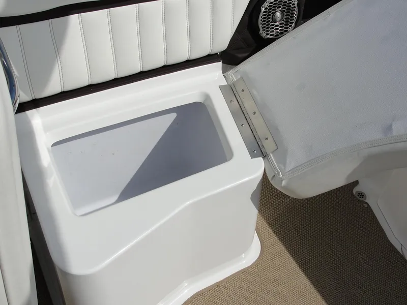 Slide: The Image of 2013 Cobalt A25 boat storage compartment with open lid, white interior, and cushioned seating. - 28