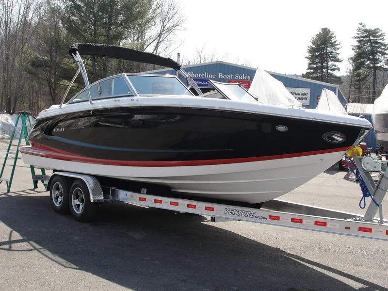 Slide: The Image of 2013 Cobalt A25 boat on trailer, black and white with red stripe, parked outdoors. - 3
