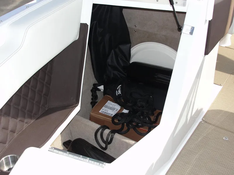 Slide: The Image of 2013 Cobalt A25 boat storage compartment with ropes and a box inside. - 38