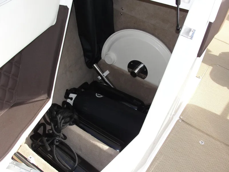 Slide: The Image of Storage compartment in a 2013 Cobalt A25 boat, featuring ropes and equipment. - 44