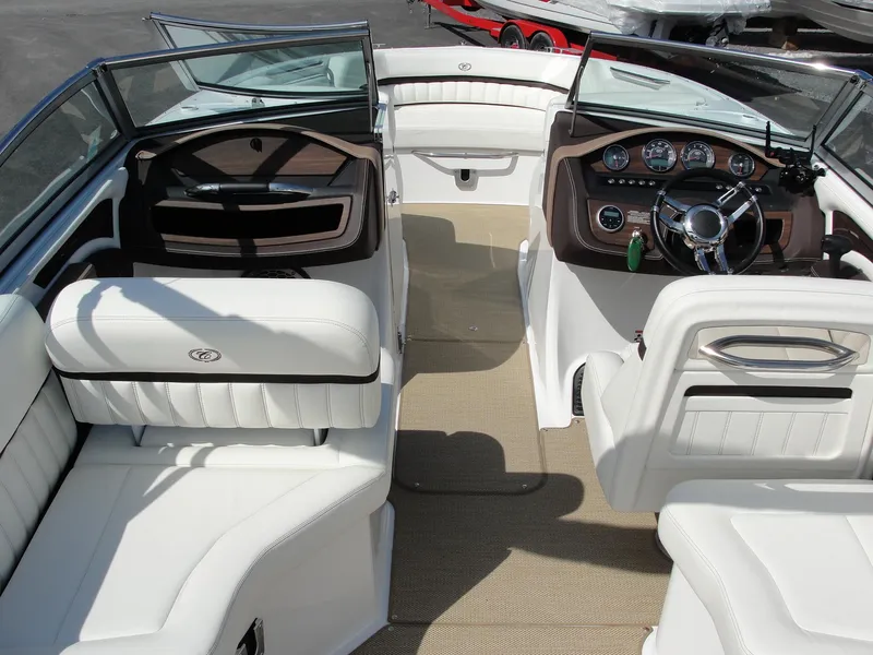 Slide: The Image of 2013 Cobalt A25 boat interior with white seating and sleek dashboard design. - 6