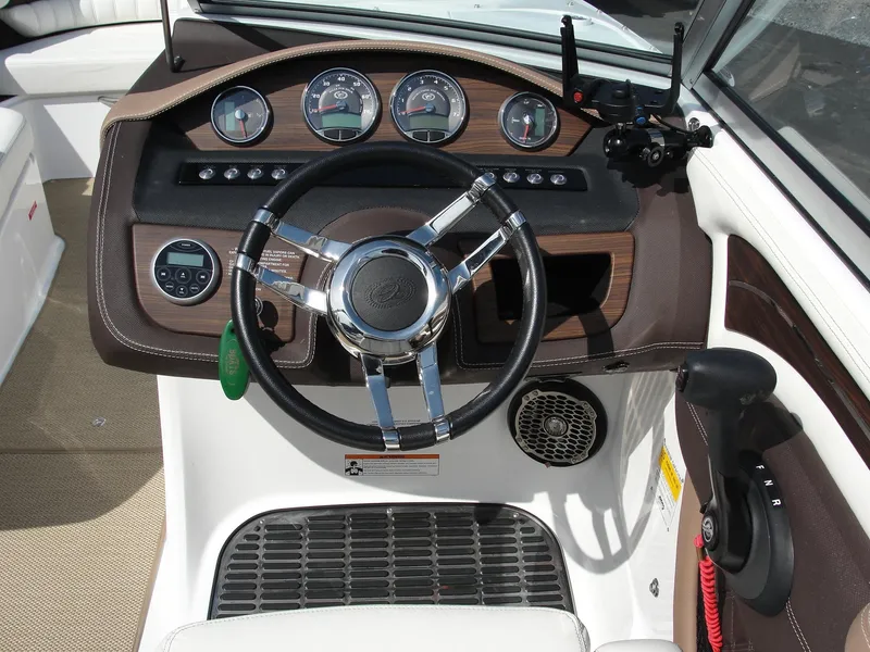 Slide: The Image of Steering wheel and dashboard of a 2013 Cobalt A25 boat, featuring gauges and controls. - 7