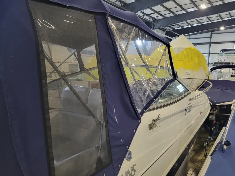 Slide: The Image of 2003 Four Winns 248 Vista boat with blue canopy in indoor storage. - 15