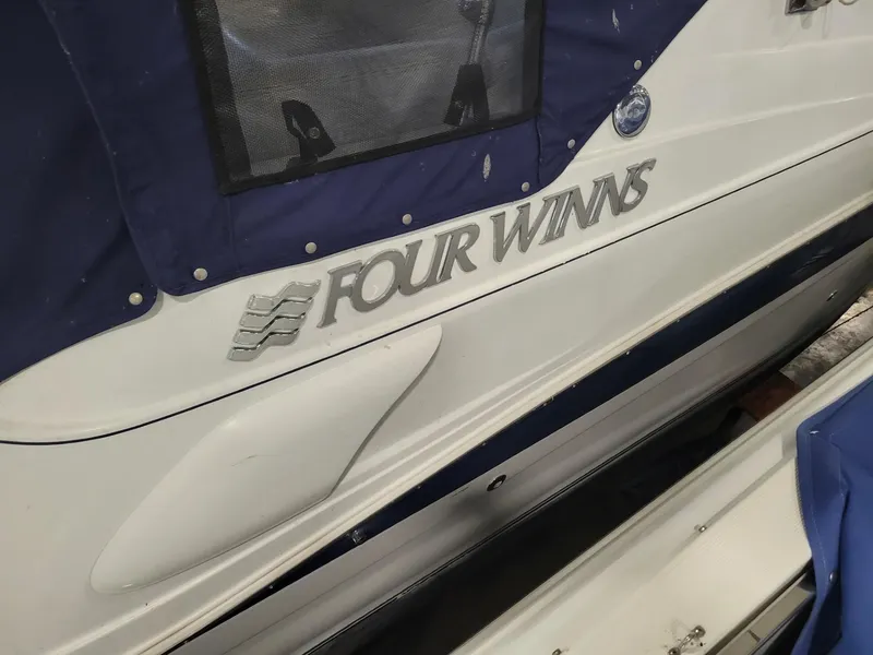 Slide: The Image of 2003 Four Winns 248 Vista boat with blue cover and logo detail. - 18