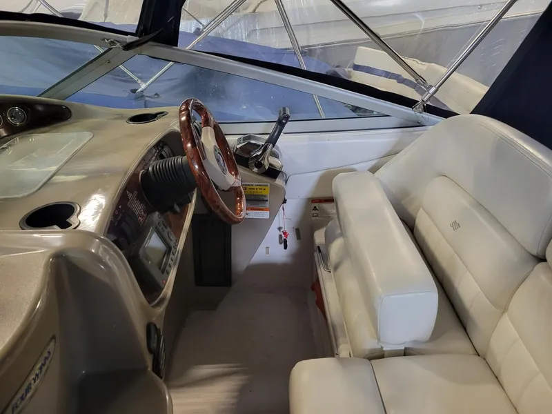 Slide: The Image of 2003 Four Winns 248 Vista boat interior with steering wheel and white seating. - 4