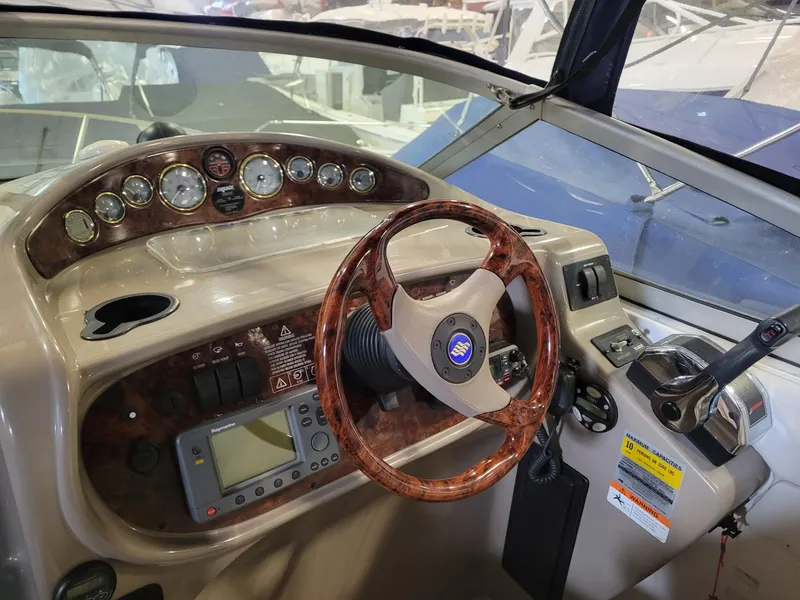 Slide: The Image of 2003 Four Winns 248 Vista boat dashboard with wood-trimmed steering wheel and instrument panel. - 5