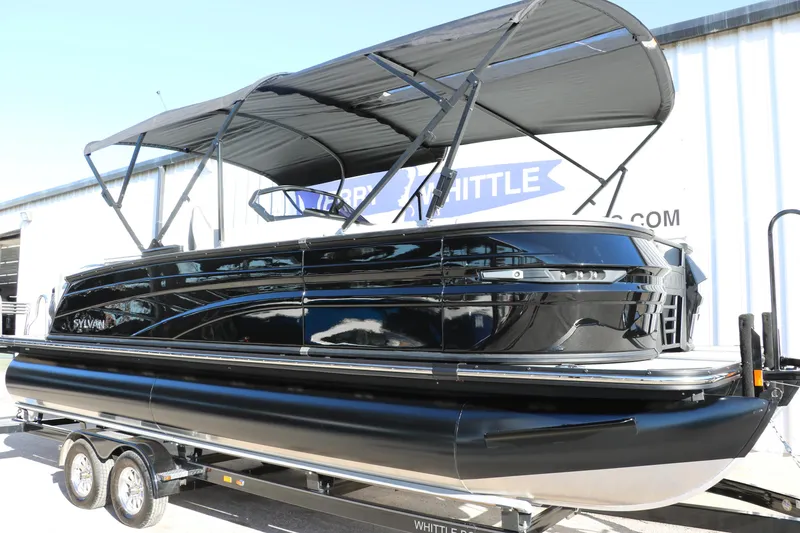 Slide: The Image of 2025 Sylvan G3 CLZ DH pontoon boat with black exterior on a trailer. - 11