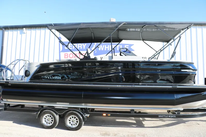 Slide: The Image of 2025 Sylvan G3 CLZ DH pontoon boat on trailer, sleek black design, outdoor display. - 13