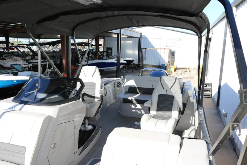 Slide: The Image of 2025 Sylvan G3 CLZ DH boat interior with modern seating and dashboard under canopy. - 18