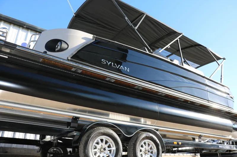 Slide: The Image of 2025 Sylvan G3 CLZ DH pontoon boat with sleek black design and canopy on trailer. - 3