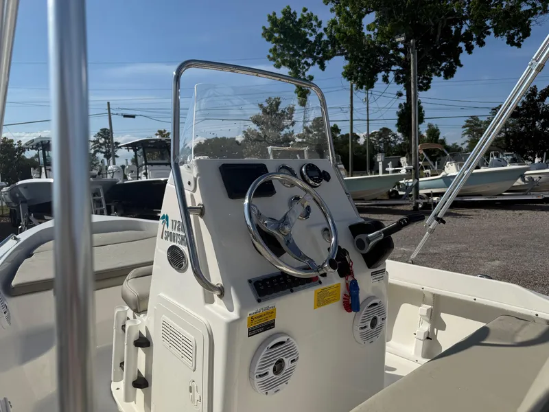 Slide: The Image of 2023 Key West 1720 Center Console boat with steering wheel and controls, parked outdoors. - 20