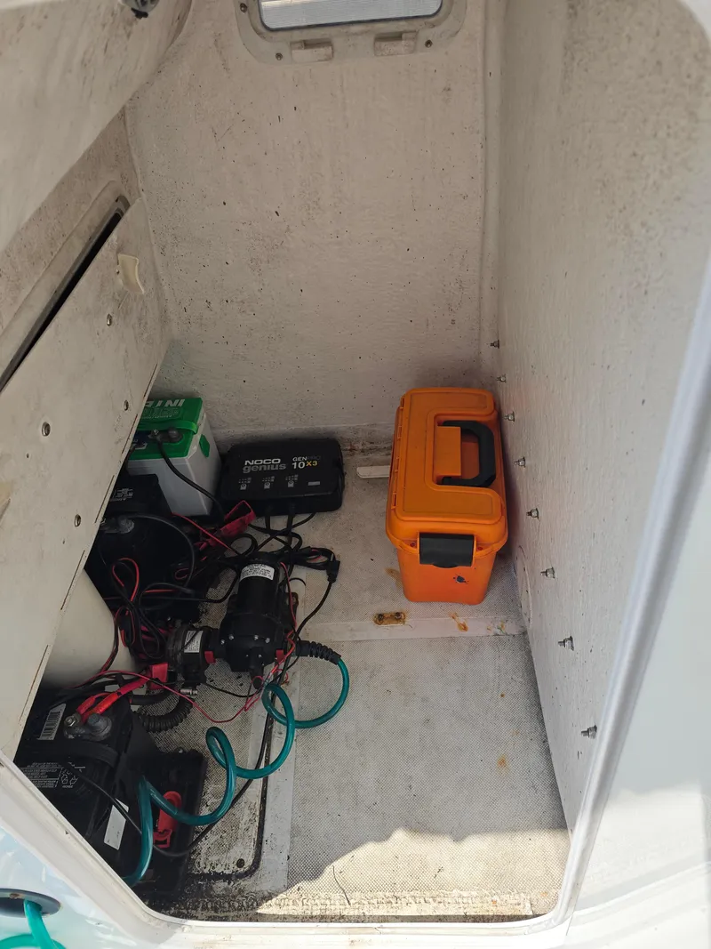 Slide: The Image of 2005 Sea Chaser 2600 Offshore boat storage compartment with batteries and equipment. - 17