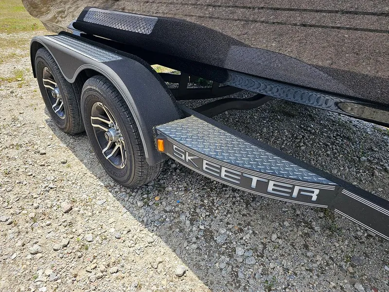 Slide: The Image of 2022 Skeeter ZX200 trailer with dual wheels on gravel surface. - 23