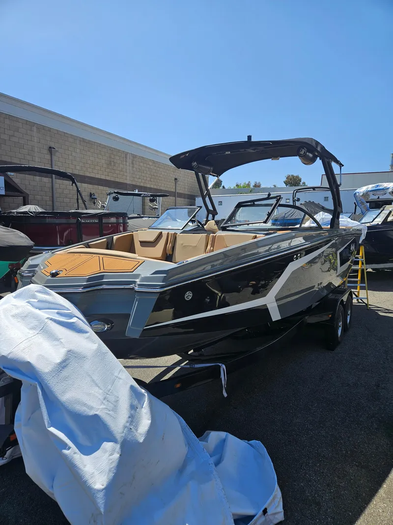 Slide: The Image of 2025 HEYDAY WAKE BOATS WT-SURF in a showroom, sleek design, black and tan colors. - 1