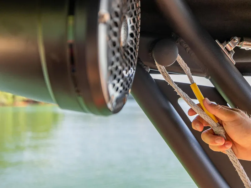 Slide: The Image of Hand adjusting rope on 2025 HEYDAY WAKE BOATS WT-SURF, near speaker system. - 17