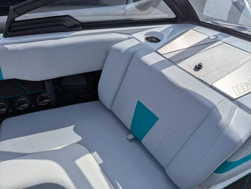 Slide: The Image of 2022 Malibu Wakesetter 23 LSV interior with white and teal seating, cup holder, and dashboard. - 12