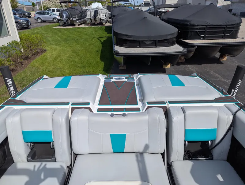 Slide: The Image of 2022 Malibu Wakesetter 23 LSV boat interior with teal accents, parked outdoors. - 15