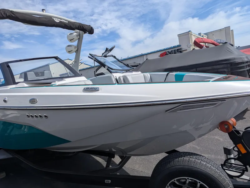 Slide: The Image of 2022 Malibu Wakesetter 23 LSV boat on trailer, sleek design, blue accents, outdoor setting. - 8