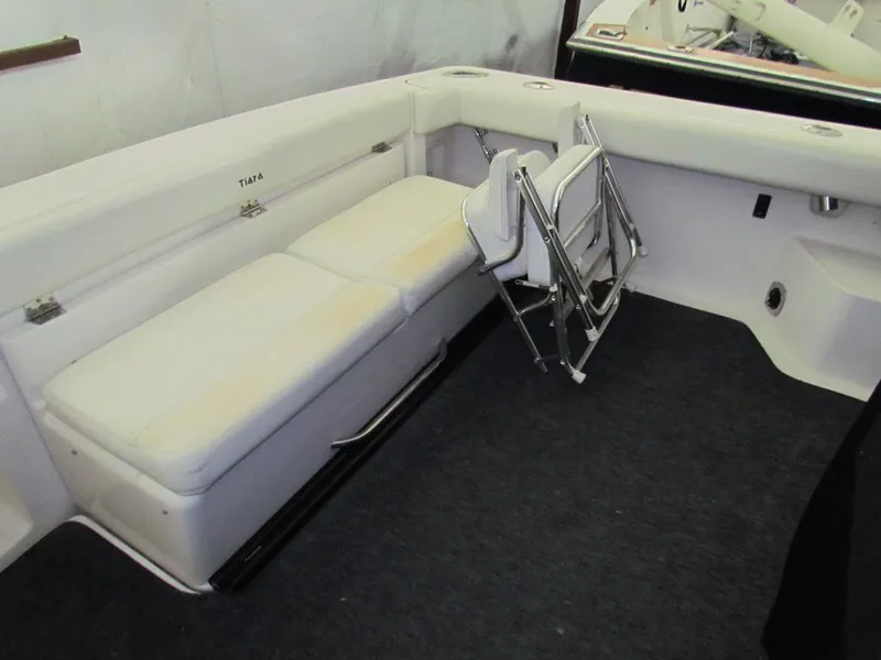 Slide: The Image of 1999 Tiara Yachts 3500 Open interior with white seating and foldable chairs. - 10
