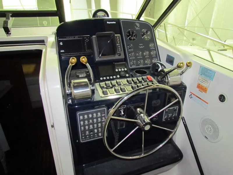 Slide: The Image of Control panel of a 1999 Tiara Yachts 3500 Open, featuring steering wheel and navigation instruments. - 12