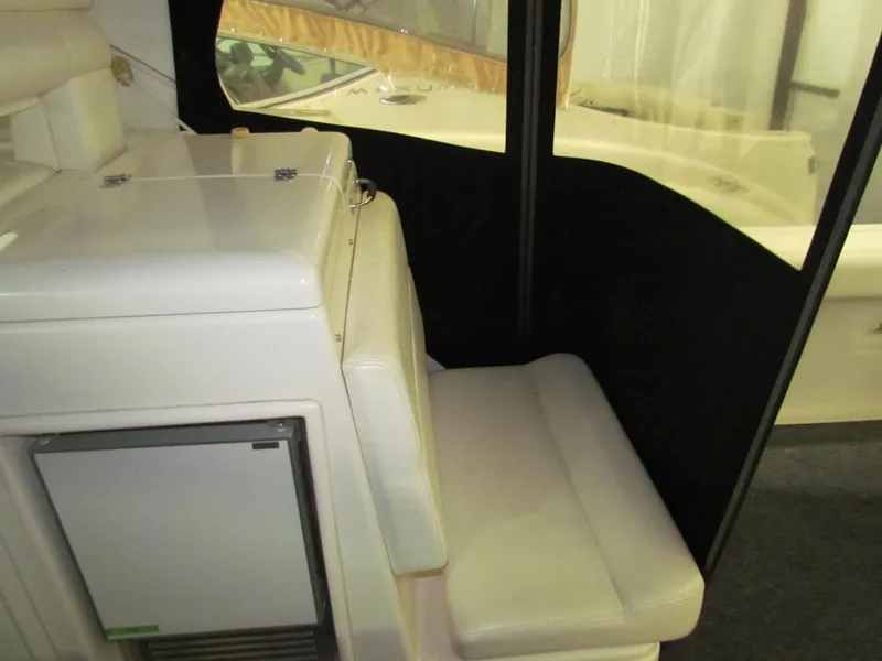 Slide: The Image of 1999 Tiara Yachts 3500 Open interior with seating and compact fridge. - 24