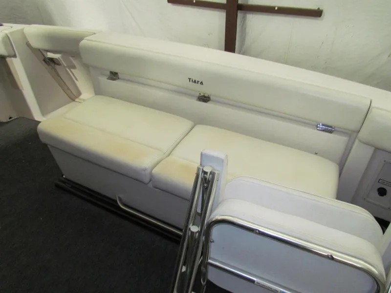 Slide: The Image of 1999 Tiara Yachts 3500 Open interior seating with white upholstery and metal accents. - 25