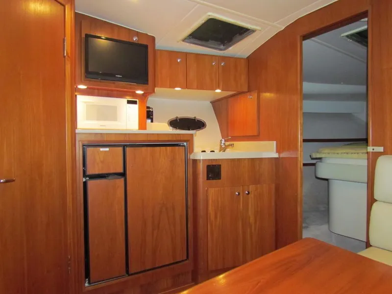Slide: The Image of 1999 Tiara Yachts 3500 Open interior with kitchenette, microwave, and wood cabinetry. - 37