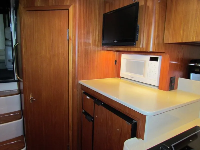 Slide: The Image of 1999 Tiara Yachts 3500 Open interior with wood cabinetry, microwave, and TV. - 38