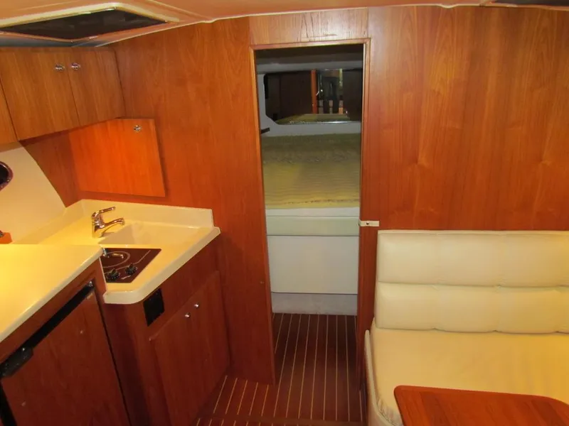 Slide: The Image of 1999 Tiara Yachts 3500 Open interior with kitchenette, seating, and cozy cabin. - 39